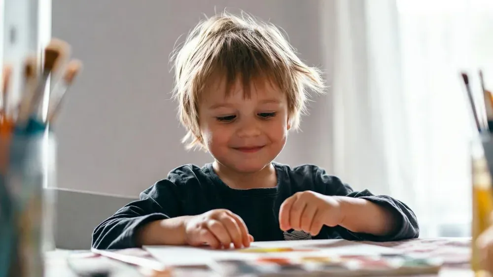 Kind spielt entspannt mit freien Händen – Kinderhypnose gegen Daumenlutschen Augsburg