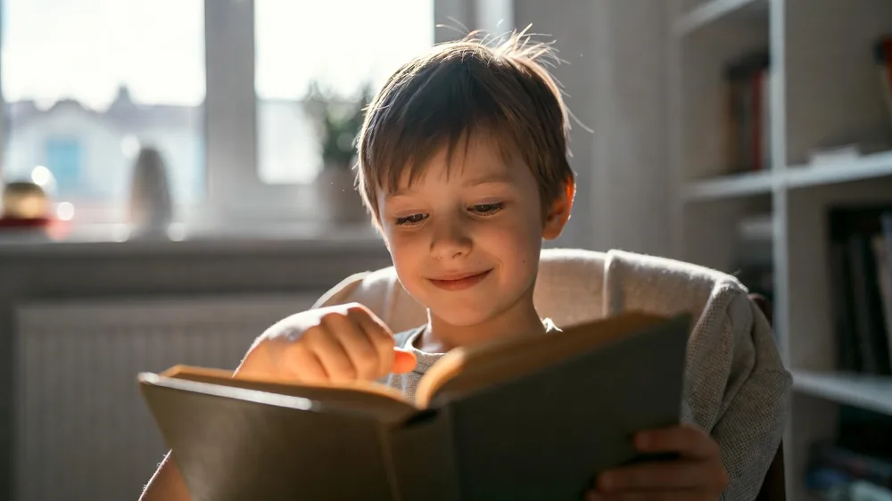 Kind liest mit Freude ein Buch – Kinderhypnose bei Leseschwäche Augsburg